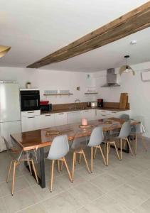 a kitchen with a large wooden table and chairs at Le Pressoir Macy - Terracobois in Choussy