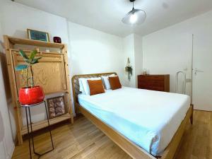 a bedroom with a bed and a potted plant at Passion et détente by UTA HOUSE in Saint-Denis