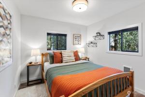 een slaapkamer met een bed en twee ramen bij Luxury A-Frame with Hot Tub, Fireplace & Firepit in Skykomish