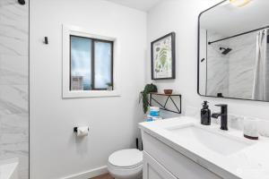 een witte badkamer met een wastafel en een toilet bij Luxury A-Frame with Hot Tub, Fireplace & Firepit in Skykomish +16 foto's