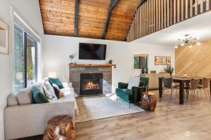 a living room with a couch and a fireplace at Luxury A-Frame with Hot Tub, Fireplace & Firepit in Skykomish