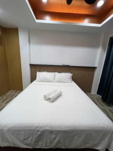 a bed with two towels sitting on top of it at Esprutingkle Business Hotel Kidapawan in Kidapawan