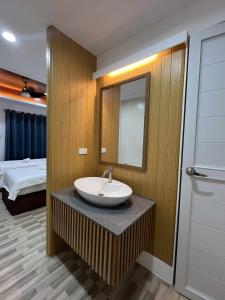 a bathroom with a sink and a mirror and a bed at Esprutingkle Business Hotel Kidapawan in Kidapawan