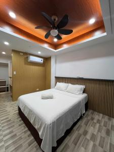 a bedroom with a bed with a ceiling fan at Esprutingkle Business Hotel Kidapawan in Kidapawan