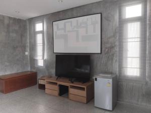 a living room with a flat screen tv on a wall at Villa89 Chumphon 