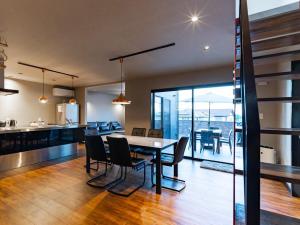 een eetkamer en keuken met een tafel en stoelen bij Kubikai in Itoshima