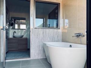 een badkamer met een wit bad en een wastafel bij Kubikai in Itoshima