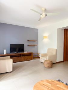 a living room with a flat screen tv and furniture at La Residence with LOV in Midlands Station