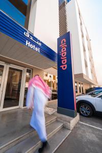 a person walking in front of a hotel with a umbrella at Dara Al Yammamah Hotel in Jeddah