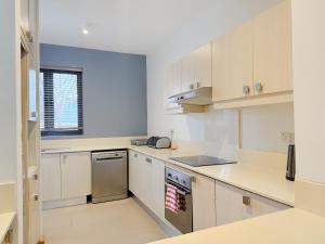 an empty kitchen with white cabinets and a window at La Residence with LOV in Midlands Station +16 photos