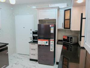 a kitchen with a refrigerator and a microwave at جرادات للشقق المفروشه in Aqaba