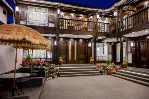 麗江市にあるGolden Dragon's Mountain Glow Innの木製のドアと花が飾られた大きな建物のあるロビー