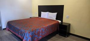 een slaapkamer met een bed met een rood en blauw dekbed bij Grapevine Inn in Lodi