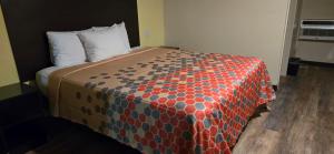 een bed met een oranje en blauw dekbed in een kamer bij Grapevine Inn in Lodi