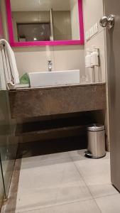 a bathroom with a sink and a mirror at ZIBE Coimbatore by GRT Hotels in Coimbatore