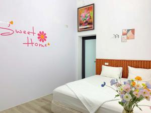 a bedroom with a bed and a vase of flowers at Bloom Homestay in Ninh Binh