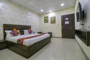 a bedroom with a large bed and a television at Hotel De Agya Paradise best hotel at ludhiana railway station in Ludhiana