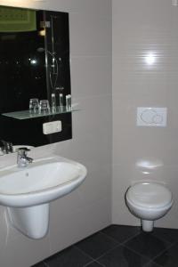 Gempfing的住宿－Helmers Gästehaus，白色的浴室设有水槽和卫生间。