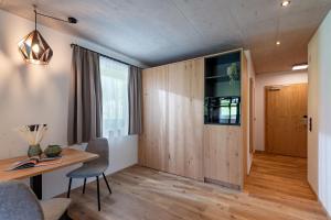 Habitación con puerta de madera, mesa y sillas en Gästehaus Schneeberger, en Mayrhofen