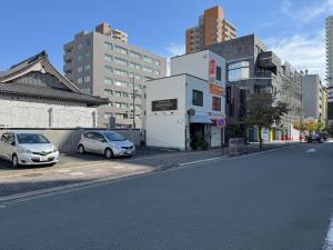 two cars parked in a parking lot next to a building at The EKAI in Toyohashi