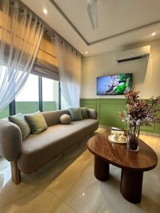 拉合尔Zameen aurum Luxury Apartment Gulberg 3 Mirhaa homes-3的客厅里有一张沙发和一张桌子。