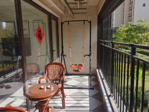 een terras met een tafel en stoelen op een balkon bij Ivy Residence in Jiaozhou
