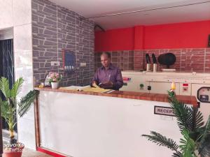 a man sitting at a counter in a kitchen at bangalore residency in Srikalahasti