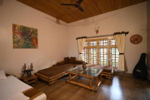 a living room with a couch and a table at Paat Halodhiya Farm Stay in Kāhārpāra