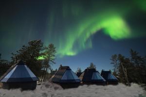 a group of tents under the aurora borealis at Wilderness Hotel Muotka & Igloos in Saariselka