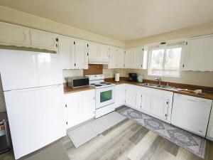 une cuisine blanche avec des armoires blanches et un évier dans l'établissement Cozy home, Walk to Lake, Food & Shops, EV Charger, à Lake Stevens