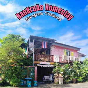 a pink house with a sign that reads building homestead break up at Ban Kru Ae mixed dorm in Ban Don Muang