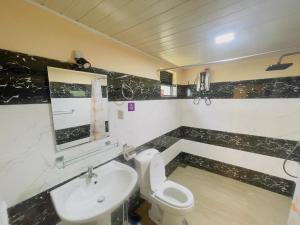 a bathroom with a white toilet and a sink at Beach Cabanas Hiriketiya in Hiriketiya