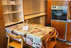 a kitchen with a table with chairs and a microwave at Marrileva-Folgarida, Apartmán v Residence Albare in Mezzana