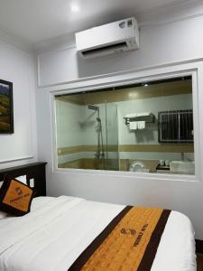 a bedroom with a large window with a bath tub at Friendly Hotel in Dồng Văn