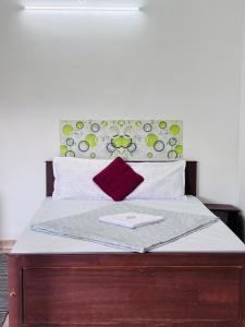 una cama con cabecero de madera con un plato encima en SAI HOLIDAYS Chottupara, en Vagamon 5 fotos más