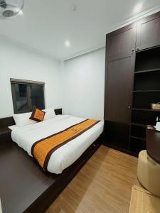 a bedroom with a large bed and a brown cabinet at Friendly Hotel in Dồng Văn