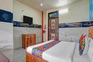 Un dormitorio con una cama y un televisor. en Via Royal Plaza 62, en Noida