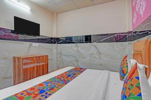 Un dormitorio con una cama con un televisor en la pared. en Via Royal Plaza 62, en Noida