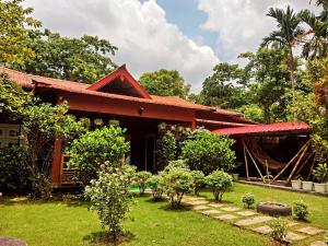 a house with a garden in front of it at Paat Halodhiya Farm Stay in Kāhārpāra