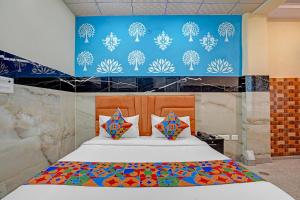 Un dormitorio con una cama con una pared azul. en Via Royal Plaza 62, en Noida