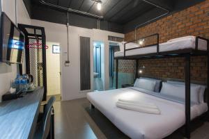 a bedroom with a bunk bed and a brick wall at City Hotel Krabi in Krabi