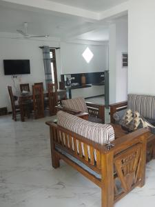 ein Wohnzimmer mit einer Couch sowie Tischen und Stühlen in der Unterkunft Luna Villa in Mawadawila