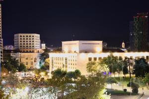 eine Gruppe von Gebäuden in einer Stadt bei Nacht in der Unterkunft The Central Spot - Grand Suite in Tirana