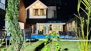 Black Rose 5 BHK Premium Luxurious villa في Nāi: منزل به حوض سباحة في الفناء