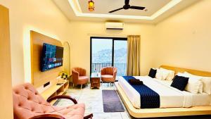 Black Rose 5 BHK Premium Luxurious villa في Nāi: غرفه فندقيه سرير وكراسي وتلفزيون +37 صورة