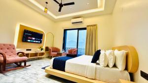 Black Rose 5 BHK Premium Luxurious villa في Nāi: غرفة نوم بها سرير وتلفزيون في الغرفة