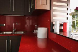 eine rote Küche mit Spüle und roter Arbeitsplatte in der Unterkunft The Central Spot - Grand Suite in Tirana + 56 Fotos