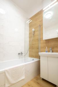 バラトンセメッシュにあるSzemesBay Apartmentの浴槽と洗面台のある白いバスルーム