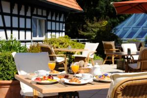 a wooden table with plates of food and drinks at VILA VITA Burghotel Dinklage in Dinklage