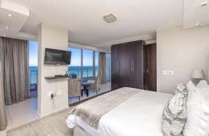a bedroom with a bed and a view of the ocean at Infinity Self Catering Apartments in Bloubergstrand +12 photos